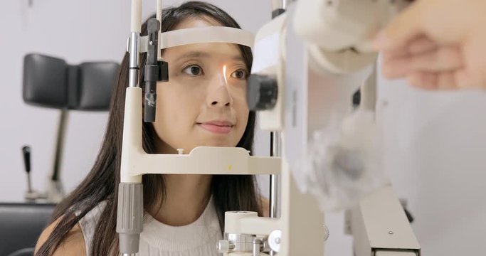 Woman in optometrists office checking her vision