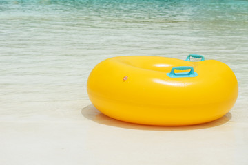 Vibrant yellow Inflatable tube at the white sand beach
