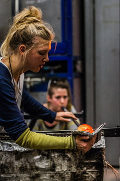 Two Women Shaping glass on the Blowpipe