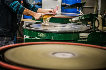 Naklejka premium Man Working a Glass Blown Vase on Silica Sanding Disk