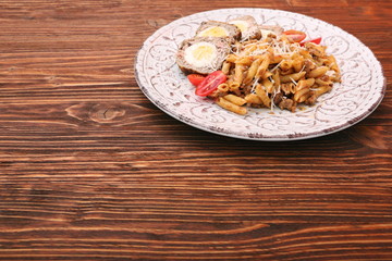 Boiled eggs in a layer of sausage meat wrapped with pasta