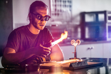 Glassblowing Young Man Working on a Torch Flame with Glass Tubes
