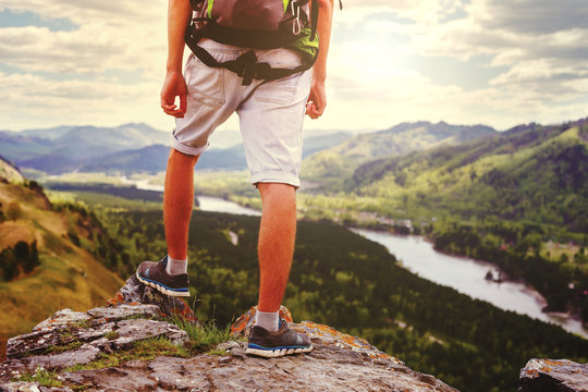 Young Man Traveler feet standing alone with  mountains on background.
