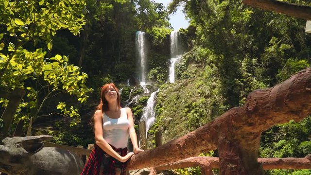 Young woman standing in front of Tamaraw falls in Puerto Galera, Philippines