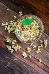 green tea with jasmine in cup and teapot on wooden table on green background