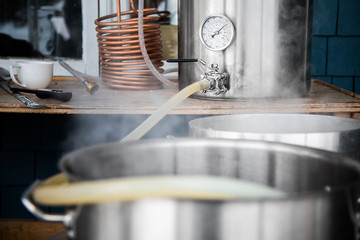 Home Brewing Kit and Pouring Craft Beer Wort into the Boil Kettle.