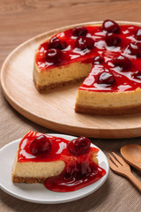 Delicious homemade cheesecake with strawberries on wooden table.
