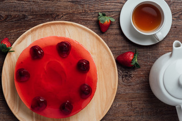 top view on strawberry cheesecake with fresh strawberries and tea in cup
