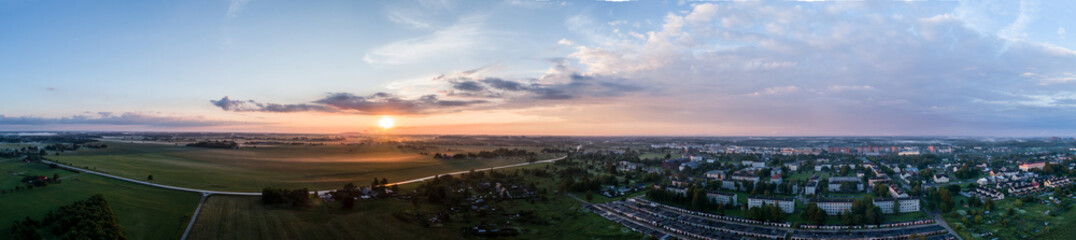 Aerial view of city in fog at amazing sunset. Summer nature landscape. Panorama.