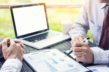 Business people discuss together about there work by graph document and setting in outdoor for planning financial strategy.