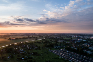 Aerial view of city in fog at amazing sunset. Summer nature landscape.