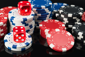 Dice and poker chips on top of black poker table