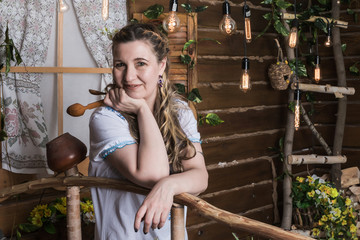 Ugly woman in national dress posing in a rustic interior
