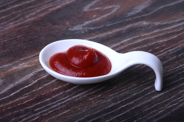 white porcelain bowl of ketchup or tomato sauce isolated on wooden background.
