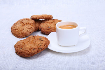 Classic espresso in white cup with cake and chocolate on white background.