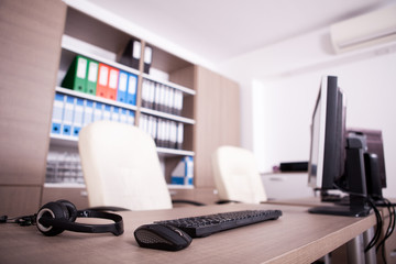 Close up of keyboard, mouse and headset on office table. Modern interior design