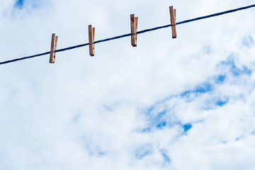 Four Laundry clips on rope for hanging on blue sky