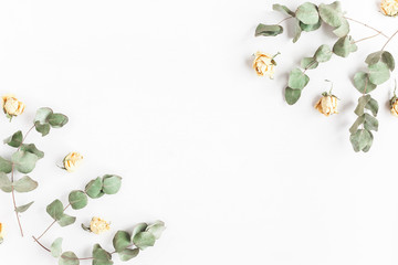 Flowers composition. Frame made of rose flowers and dried eucalyptus branches on white background. Flat lay, top view - obrazy, fototapety, plakaty