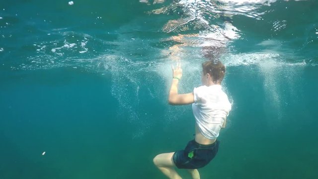 man sinking into the sea, half underwater close up, raw, 4k