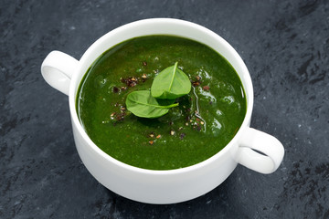 spinach cream soup on a dark background, top view