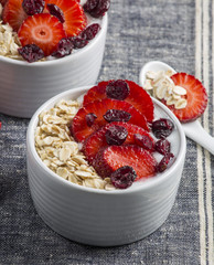 Yogurt with oat flake and fresh berries for healthy morning meal put on white wood background, Breakfast set.