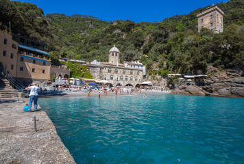 Fototapeta na wymiar SAN FRUTTUSO DI CAMOGLI, ITALY, MAY, 4, 2016 - San Fruttuoso di Camogli, Ligurian coast, Genoa province, with its ancient Abbaey, the beach and tourists.