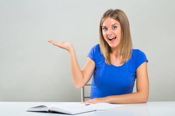 Excited female student is gesturing while studying.