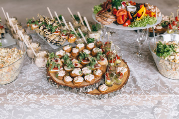 Italian antipasti wine snacks set. Brushettas, cheese variety, Mediterranean olives, pickles, Prosciutto di Parma with melon, salami and wine in glasses over black grunge background, top view