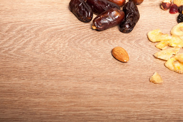 Mix of different dried fruits on wooden background. Healthy raw organic snack
