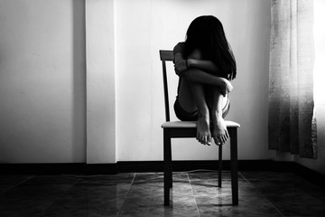 depress and hopeless girl sitting on chair on black