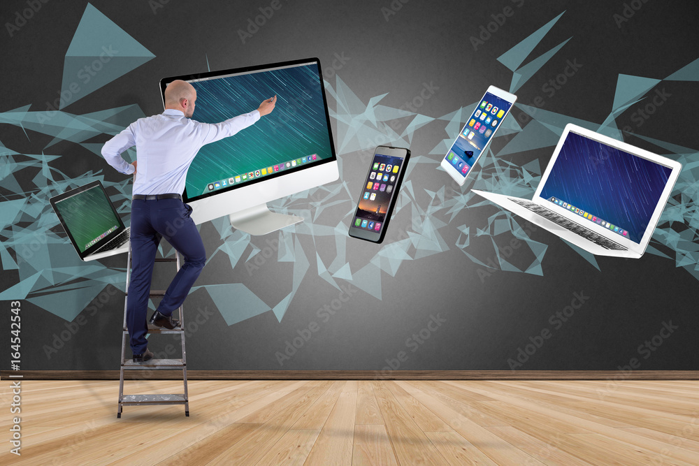 Poster businessman in front of a wall with computer and devices displayed on a futuristic interface with in