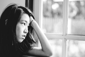 depress and hopeless girl with absent minded looking outside