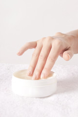 Closeup of female hands applying cream