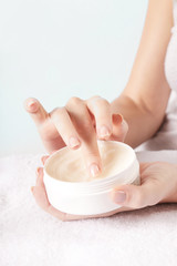 Closeup of female hands applying cream