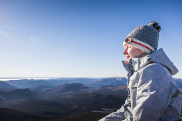 Fototapeta na wymiar Happy Woman Enjoying the View of the Richardson Mountain's Summit