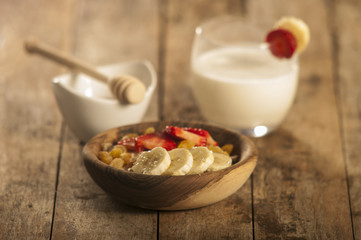 oatmeal porridge with strawberry and banana in wood bowl
