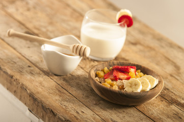 oatmeal porridge with strawberry and banana in wood bowl