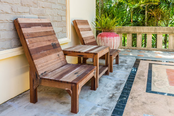Fototapeta na wymiar Natural wooden armchairs on patio for relaxation. They are made of wood lumber.