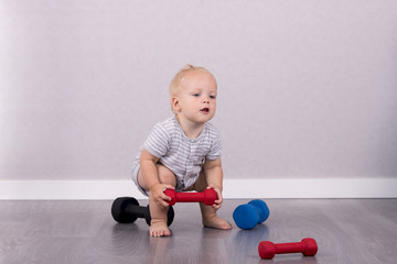 Cute toddler lifting a weight like a professional athlete