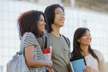 Multiethnic group of young students standing outdoors talking