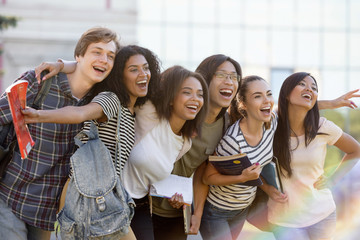 Multiethnic group of young happy students standing outdoors