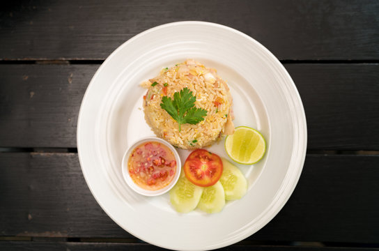 Thai Healthy food : fried rice chicken with egg and green coriander leaves and side dish.  (Asian fried rice) view from above on dark wood.