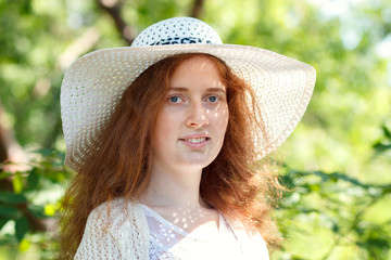 Portrait of happy red-haired girl in the open air.