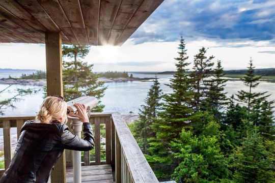 Young Woman Looking at the Amazing Nature Through a Binocular in a Observation Tower