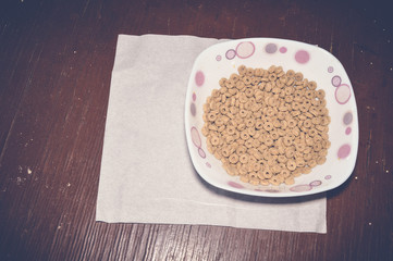 corn flakes in a bowl on wooden table