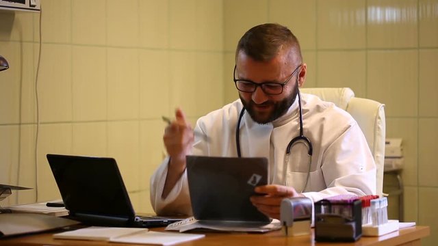 Doctor checking x-ray and telling good news to the camera
