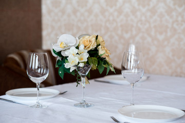 Dining table setting decorated with flowers.
