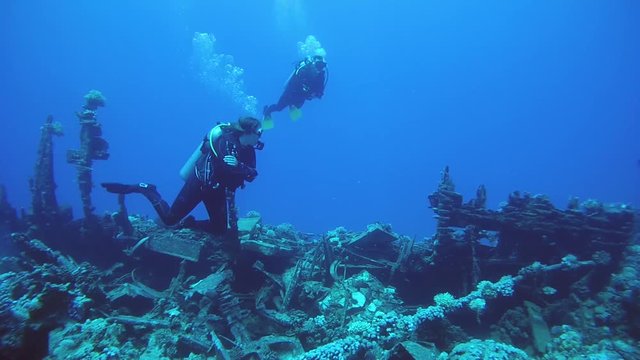 RED SEA, MARSA ALAM, EGYPT, AFRICA - JULE 2017: Scuba divers inspecting the shipwreck

