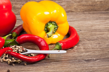 Spicy and sweet pepper on wooden background in studio photo. Healthy eating