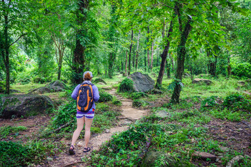 Obraz premium Adventuress or traveler woman go hiking on trail in forest. The tropical jungle in Southeast Asia.